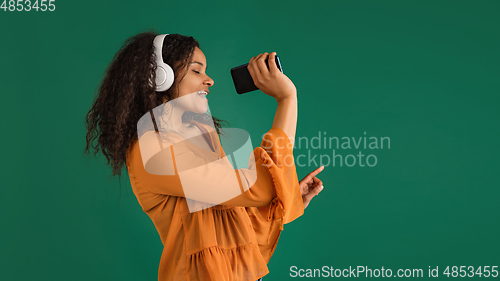 Image of African-american woman portrait isolated on green studio background with copyspace