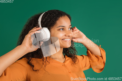 Image of African-american woman portrait isolated on green studio background with copyspace