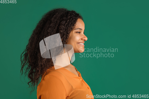 Image of African-american woman portrait isolated on green studio background with copyspace