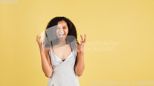 Image of African-american woman portrait isolated on yellow studio background with copyspace