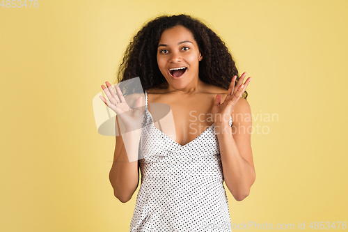 Image of African-american woman portrait isolated on yellow studio background with copyspace