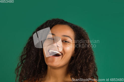 Image of African-american woman portrait isolated on green studio background with copyspace