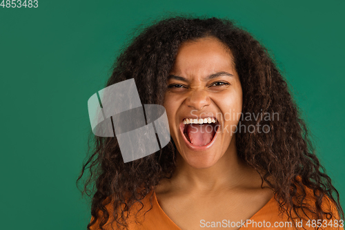 Image of African-american woman portrait isolated on green studio background with copyspace