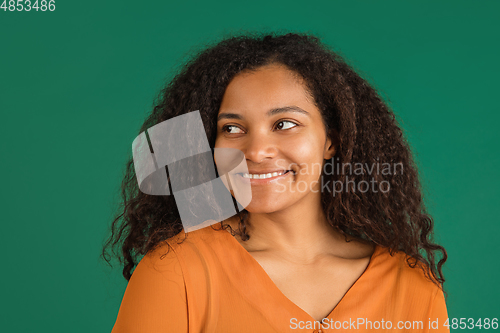 Image of African-american woman portrait isolated on green studio background with copyspace