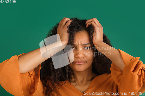 Image of African-american woman portrait isolated on green studio background with copyspace