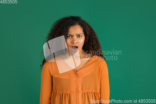 Image of African-american woman portrait isolated on green studio background with copyspace