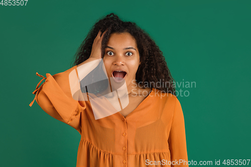 Image of African-american woman portrait isolated on green studio background with copyspace