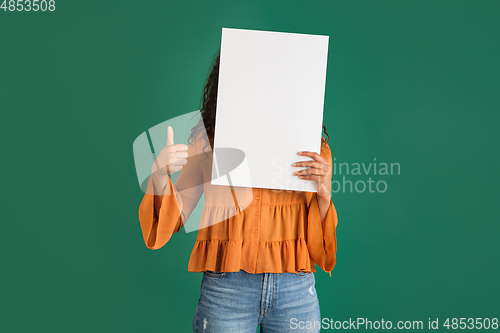 Image of African-american woman portrait isolated on green studio background with copyspace