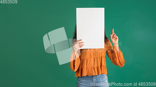 Image of African-american woman portrait isolated on green studio background with copyspace