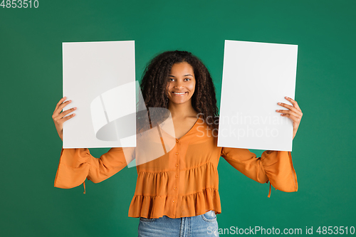 Image of African-american woman portrait isolated on green studio background with copyspace