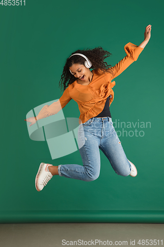 Image of African-american woman portrait isolated on green studio background with copyspace