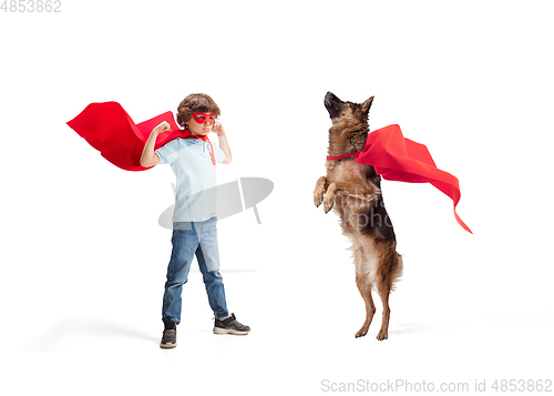 Image of Child pretending to be a superhero with his super dog isolated on white studio background