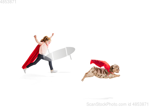 Image of Child pretending to be a superhero with her super dog isolated on white studio background