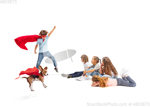 Image of Child pretending to be a superhero with his super dog and friends sitting around