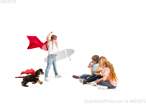 Image of Child pretending to be a superhero with her super dog and friends sitting around