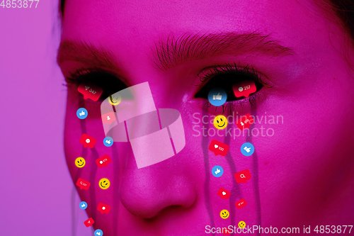 Image of Tears illustrated of social media activity signs on female face in neon light. Real life versus online lifestyle, addiction to modern technologies