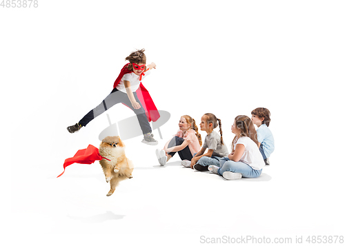 Image of Child pretending to be a superhero with his super dog and friends sitting around