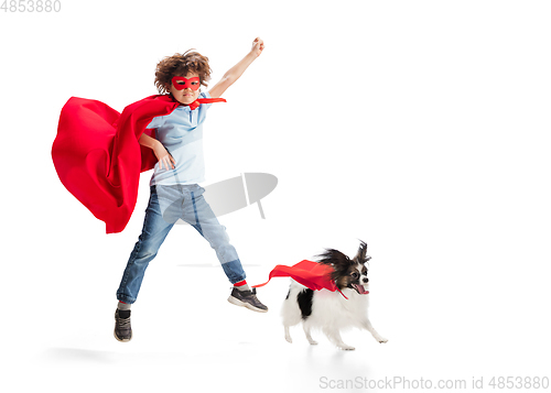 Image of Child pretending to be a superhero with his super dog isolated on white studio background