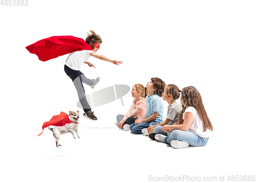 Image of Child pretending to be a superhero with his super dog and friends sitting around