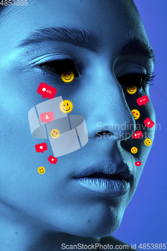 Image of Tears illustrated of social media activity signs on female face in neon light. Real life versus online lifestyle, addiction to modern technologies