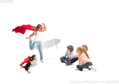 Image of Child pretending to be a superhero with her super dog and friends sitting around