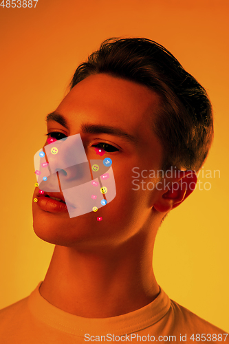 Image of Tears illustrated of social media activity signs on male face in neon light. Real life versus online lifestyle, addiction to modern technologies