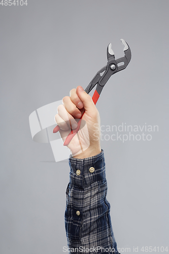 Image of close up of builder's hand holding wrench