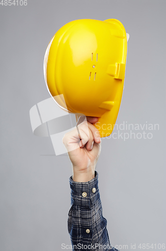 Image of close up of builder's hand holding helmet