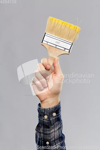 Image of close up of builder's hand holding paint brush