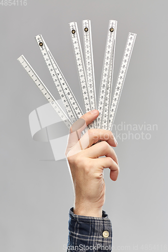 Image of close up of builder's hand holding folding ruler