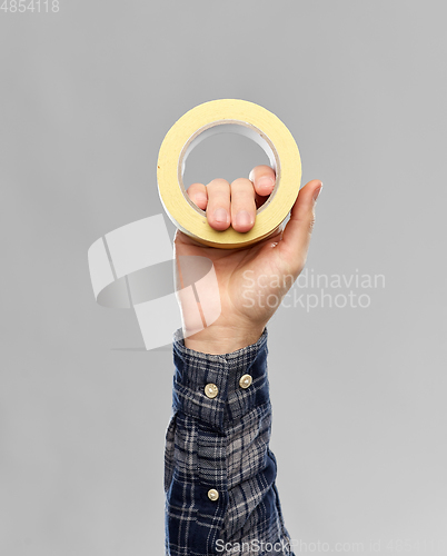 Image of close up of builder's hand holding paper tape