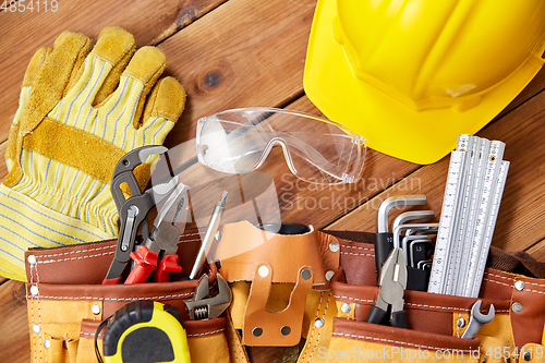 Image of different work tools in belt on wooden boards