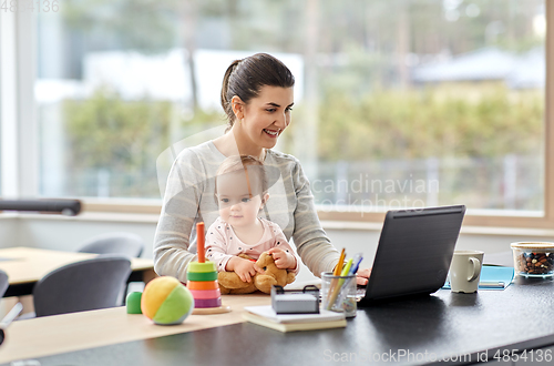 Image of mother with baby and laptop working at home office