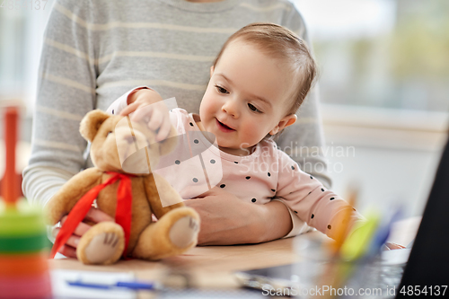 Image of happy baby with mother working at home office