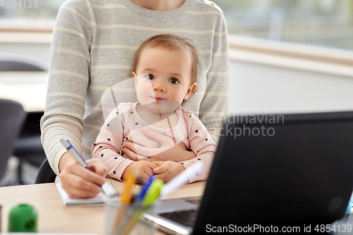 Image of mother with baby working at home office