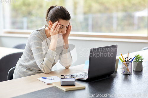 Image of tired woman with laptop working at home office