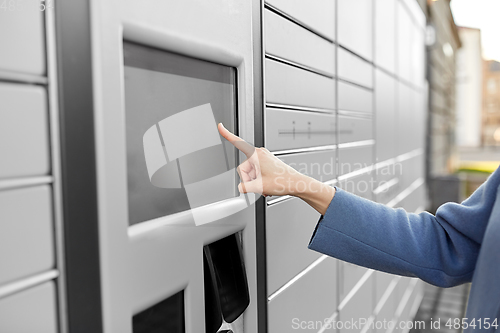 Image of close up of hand using automated parcel machine