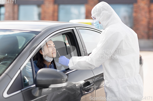 Image of healthcare worker making coronavirus test at car