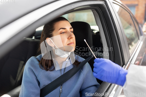 Image of healthcare worker making coronavirus test at car