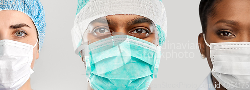 Image of close up of doctor's faces in masks over grey