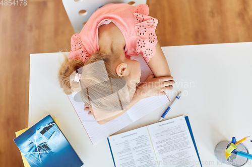 Image of tired student girl sleeping on table at home