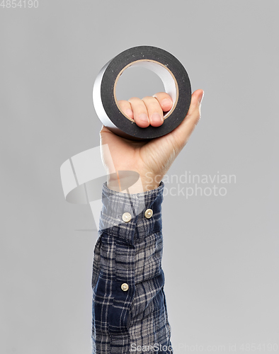 Image of close up of builder's hand holding adhesive tape