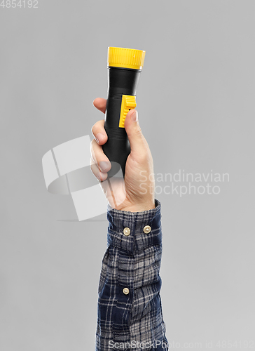 Image of close up of builder's hand holding flashlight