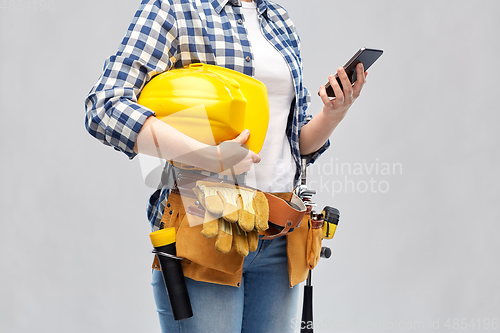 Image of woman or builder with phone and working tools