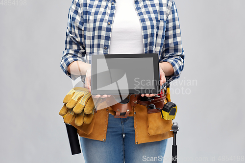 Image of woman builder with working tools showing tablet pc