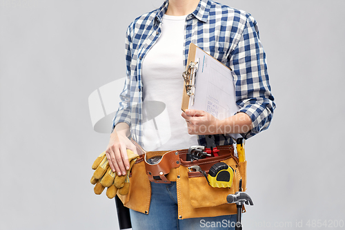Image of woman with clipboard, pencil and working tools