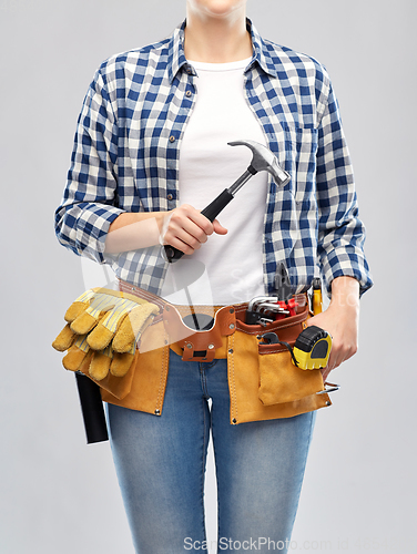 Image of woman with hammer and working tools on belt