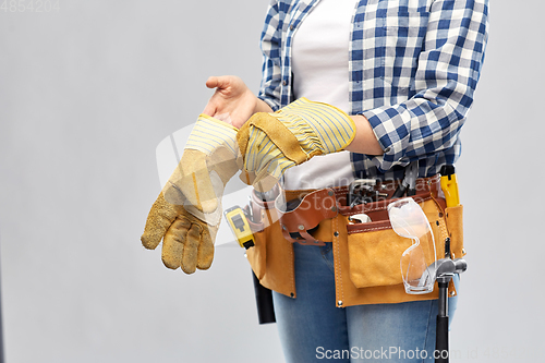 Image of woman or builder with gloves and working tools