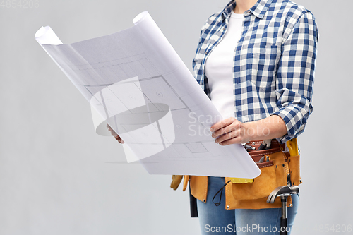 Image of female builder with blueprint and working tools