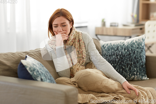 Image of sick woman in scarf coughing at home